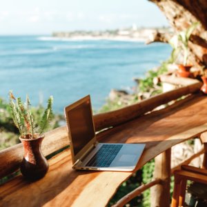 laptop on bench with sea view